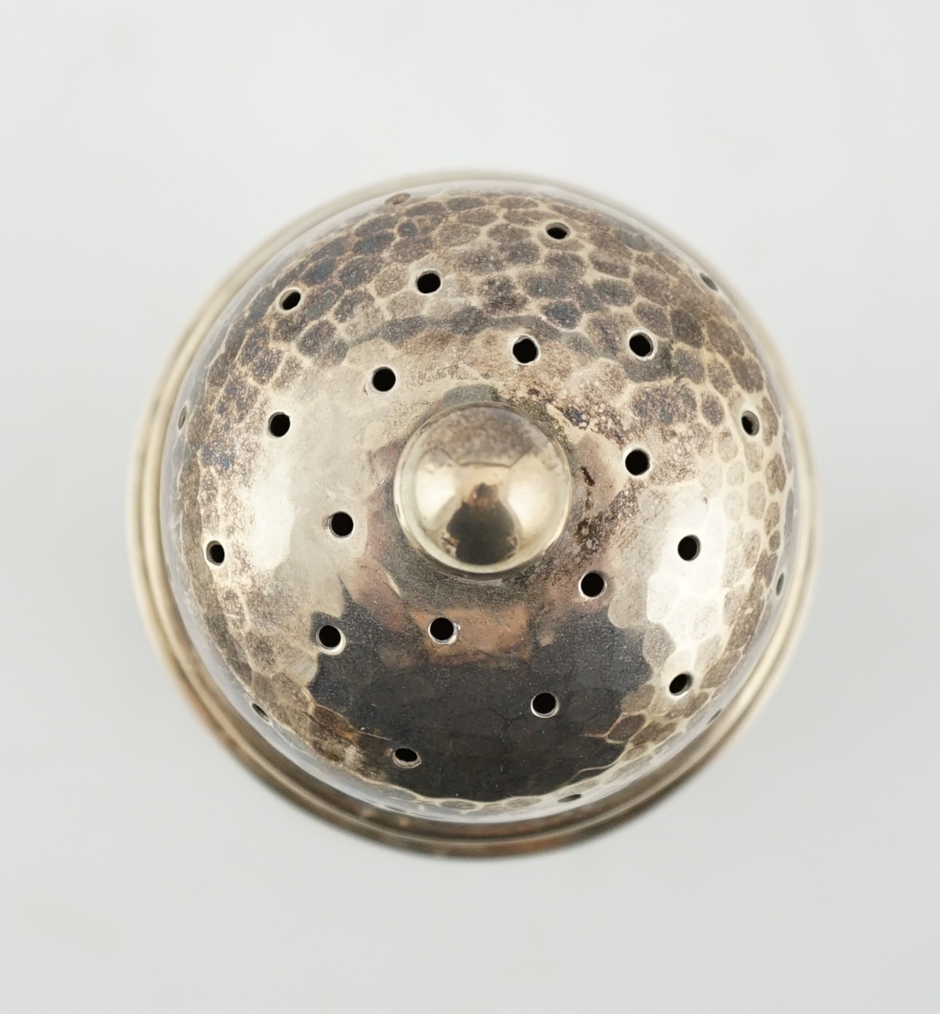 A George V Arts & Crafts planished silver sugar castor by Albert Edward Jones, of lighthouse form, Birmingham, 1929, 16.7cm, 5.3oz. Condition - fair to good